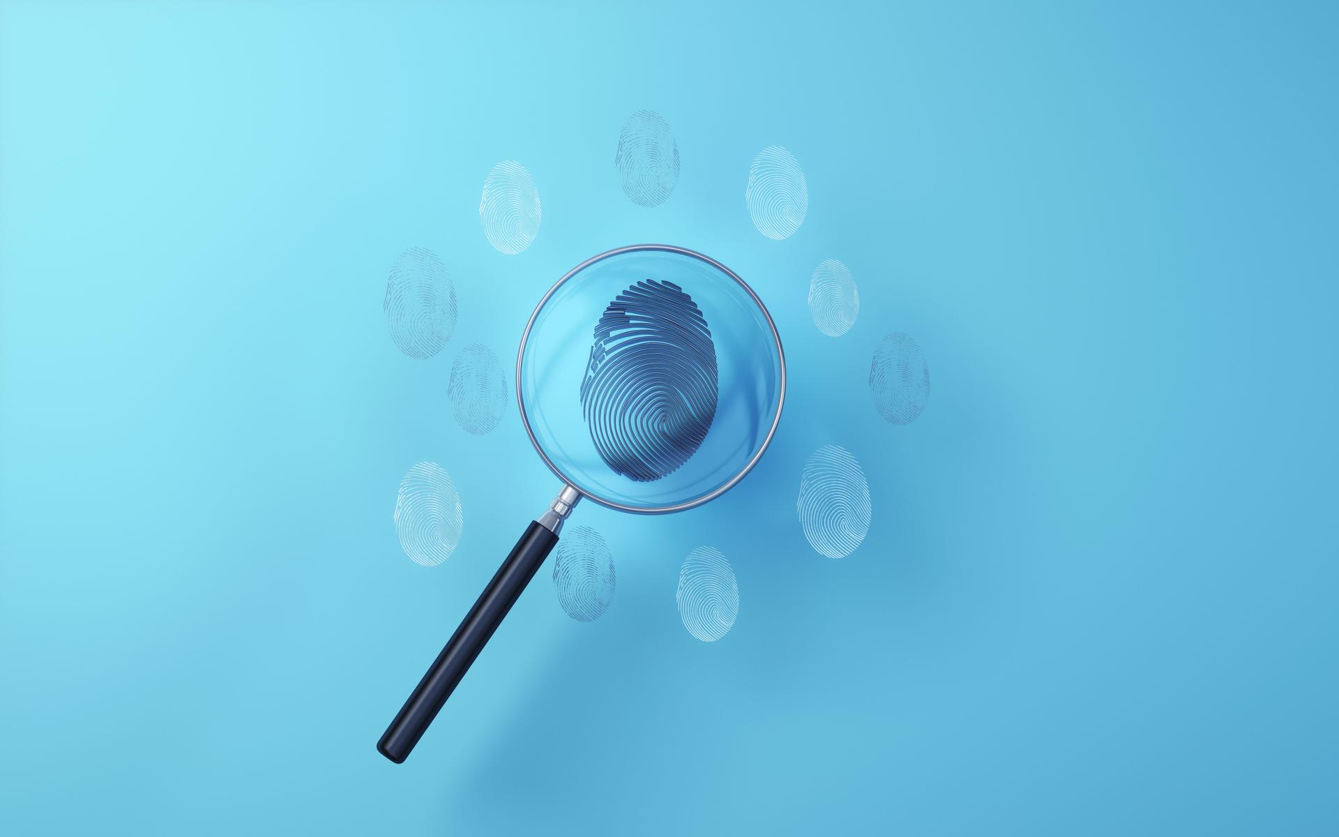 Black Metallic Fingerprint examined with metallic magnifying glass on soft blue background